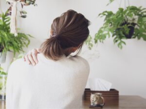 肩こりに悩む女性 - 自宅で肩こりを感じている女性の後ろ姿