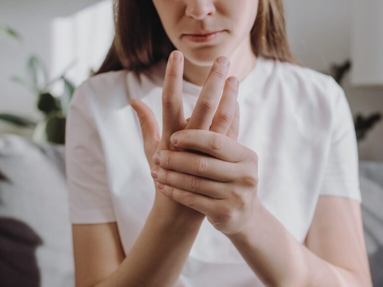 手のしびれを感じ、指を気にしている女性